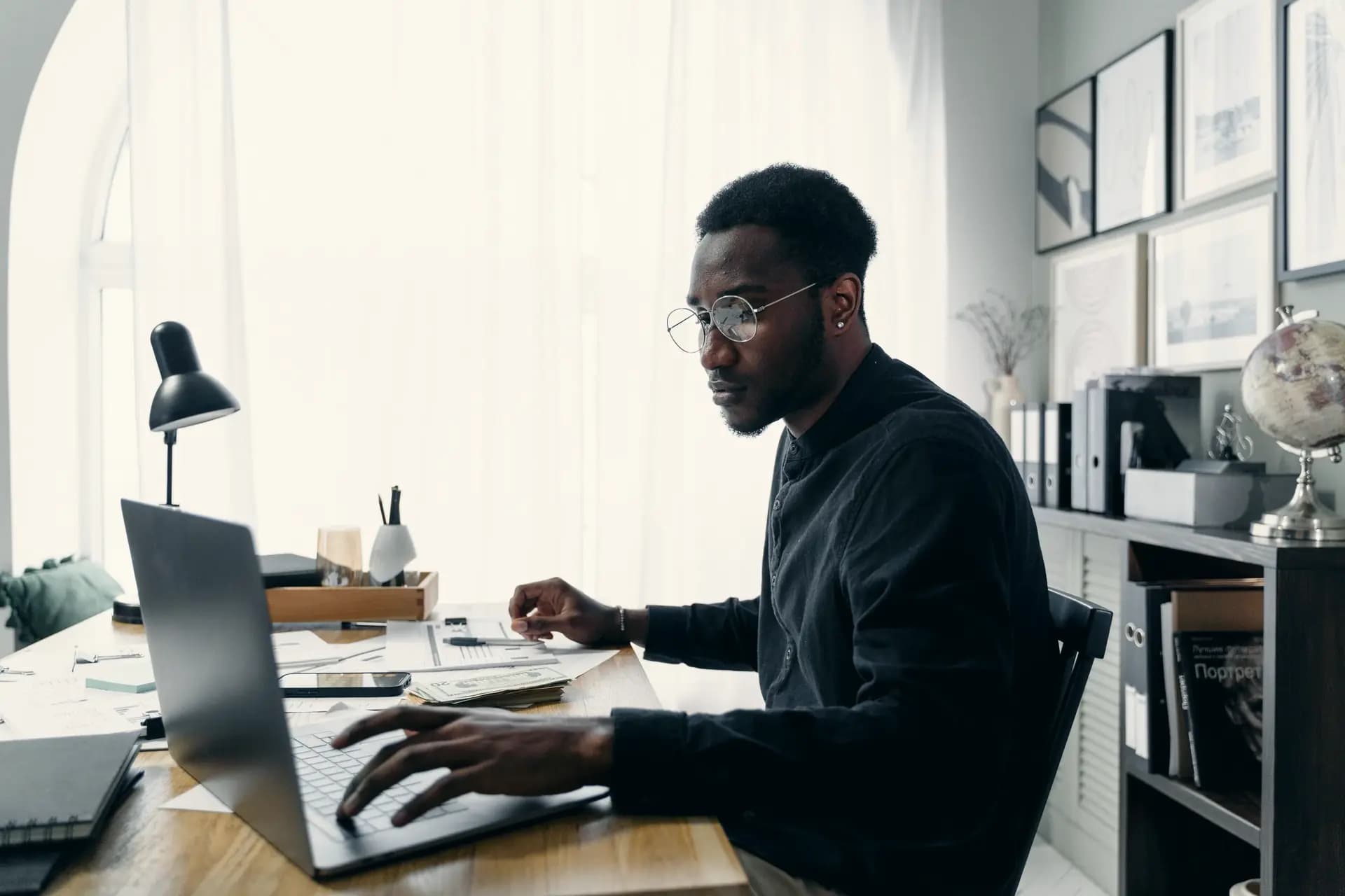 An analyst works through data on a laptop at his desk.